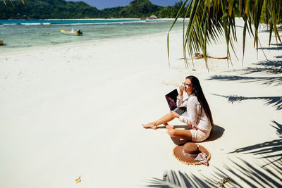 Young woman sitting on beach