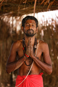 Portrait of shirtless man standing outdoors