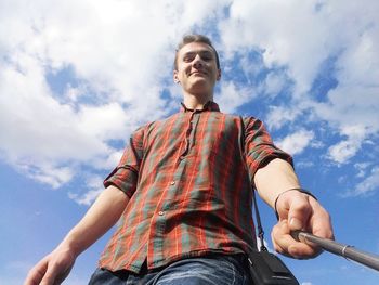 Low angle portrait of man standing against sky
