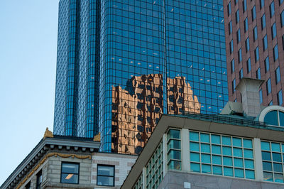 Low angle view of modern building against blue sky