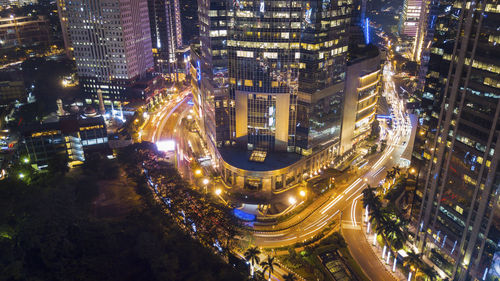 High angle view of illuminated street amidst buildings at night