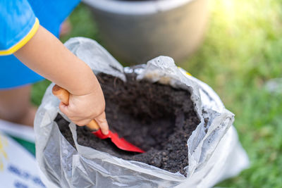 High angle view of woman holding equipment in mud