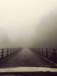 Bridge in foggy weather against sky during winter