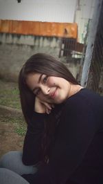 Portrait of smiling young woman sitting outdoors