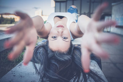 Portrait of woman with arms raised in city