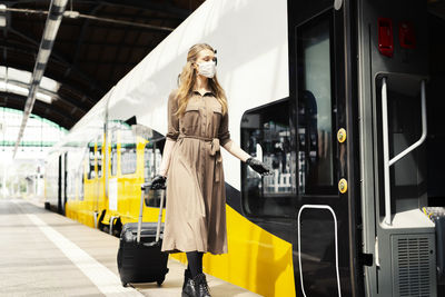 Woman standing by train