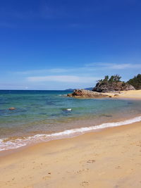 Scenic view of beach against blue sky