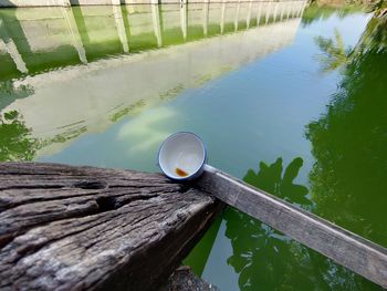 High angle view of coffee cup by lake