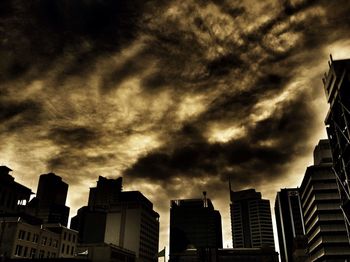 Low angle view of buildings against cloudy sky