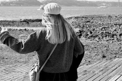 Rear view of woman standing at beach