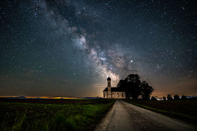 Built structure on field against sky at night