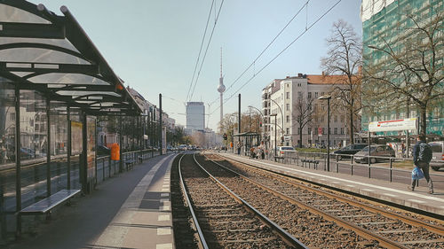 Railroad tracks in city against sky