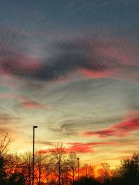 Low angle view of silhouette trees against dramatic sky