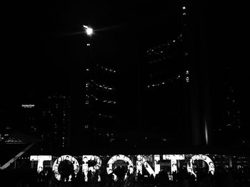 People walking in illuminated city at night