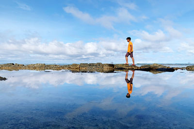 Man standing in sea against sky