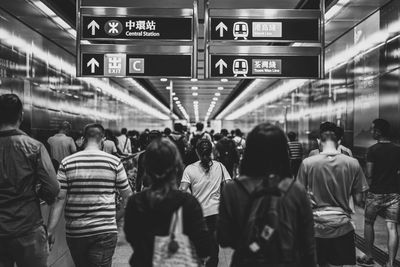 Rear view of people walking at subway station