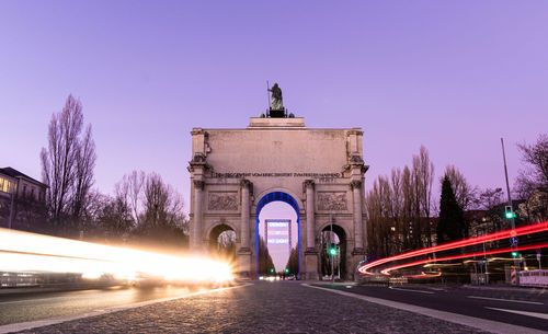 Light trails in city against sky at night