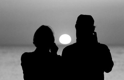 Rear view of silhouette couple against sky