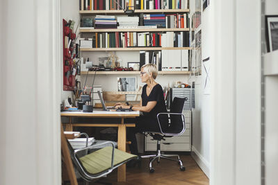 Female product designer using laptop at home office