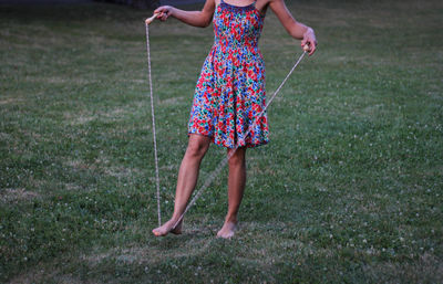 Low section of woman holding jumping rope