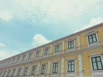 Low angle view of building against cloudy sky