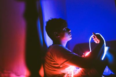 Man sitting in illuminated room