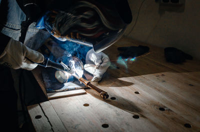 Man in protective mask. metal welding. coffee maker repair.