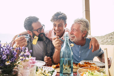 Cheerful family eating food while sitting at restaurant