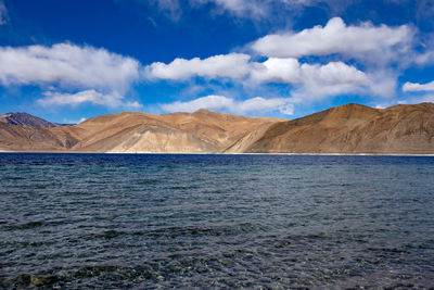 Scenic view of lake and mountains against blue sky