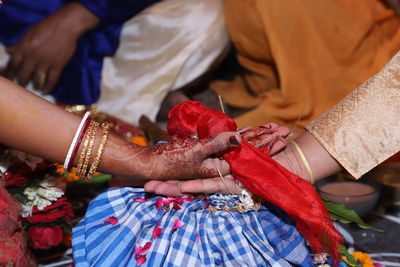 Midsection of bride and groom during wedding ceremony