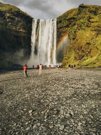 Panoramic view of people at waterfall