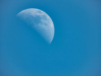 Low angle view of moon against blue sky