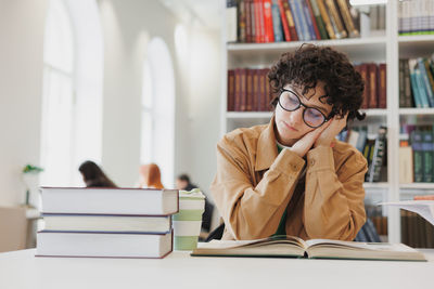 Young woman using digital tablet in library