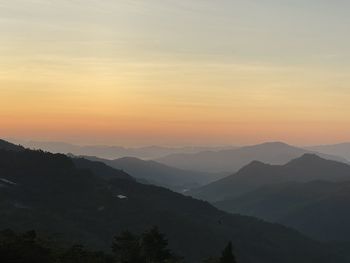 Scenic view of silhouette mountains against sky at sunset