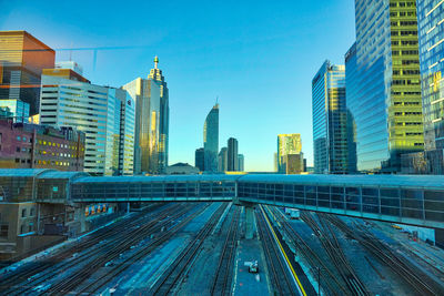 Railroad tracks in city against sky