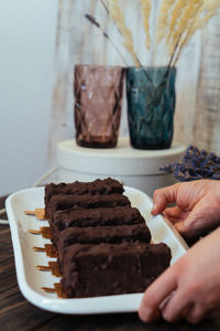 Close-up of hand holding ice cream in plate