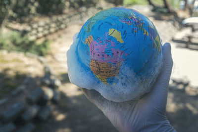 Close-up of hand holding multi colored umbrella