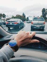 Cropped image of hand on car windshield