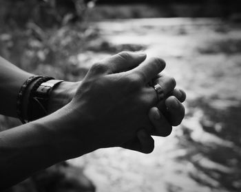 Close-up of hand holding leaf against blurred background