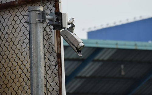 Close-up of metal fence against building