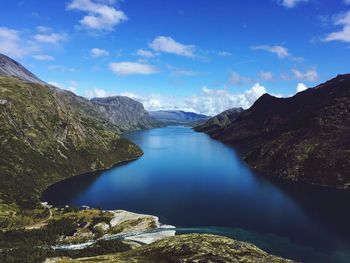 Scenic view of lake and mountains against blue sky