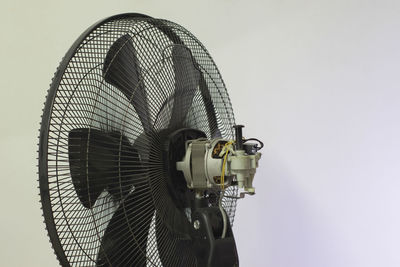 Low angle view of electric fan against white background