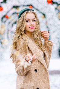 Follow me concept photo of a young girl at a christmas market holding a garland