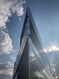 Low angle view of modern building against cloudy sky