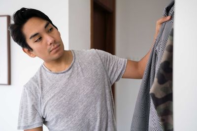 Latin man choosing clothing from his wardrobe