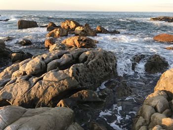 Rocks in sea against sky