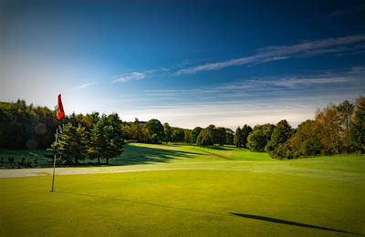 Scenic view of golf course against sky