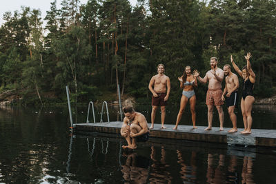 Friends cheering when man jumping into water