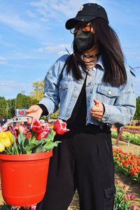 Woman standing by potted plants