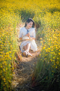 Young woman on field with yellow flowers